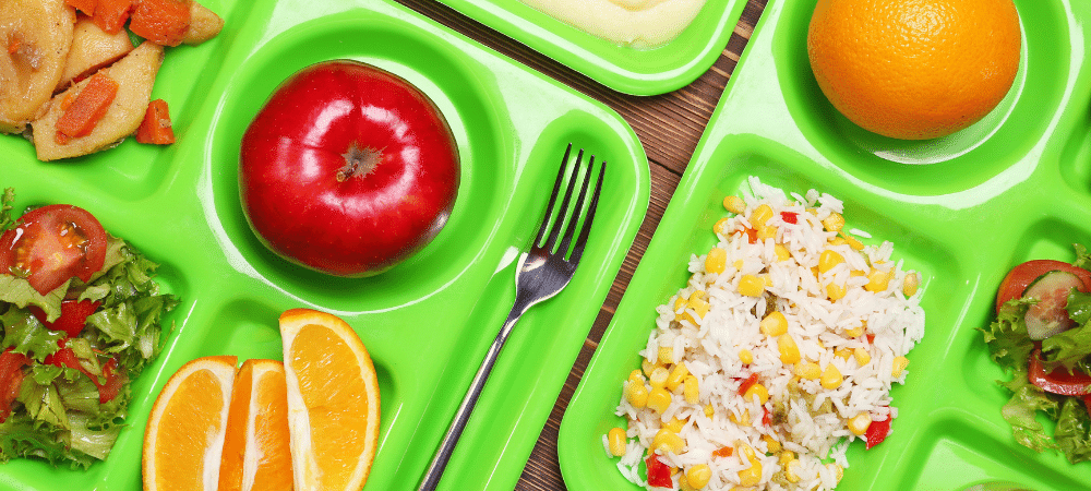 桌上放着新鲜农产品的学校午餐托盘