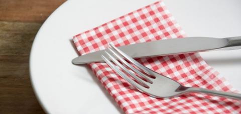 盘子里有餐巾，叉子，刀