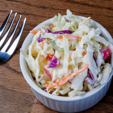 卷心菜沙拉放在白色的碗里，用叉子叉着